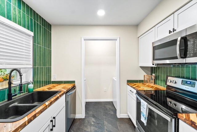 4276 Calinda Ln Apt 138, Niceville, FL 32578 - kitchen featuring stainless steel appliances, butcher block counters, white cabinets, recessed lighting, and decorative backsplash