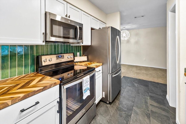 4276 Calinda Ln Apt 138, Niceville, FL 32578 - kitchen with stainless steel appliances, white cabinets, decorative backsplash, and butcher block counters
