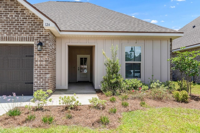 124 Apollo Ave, Freeport, FL 32439 - property entrance featuring brick siding, a shingled roof, board and batten siding, and an attached garage