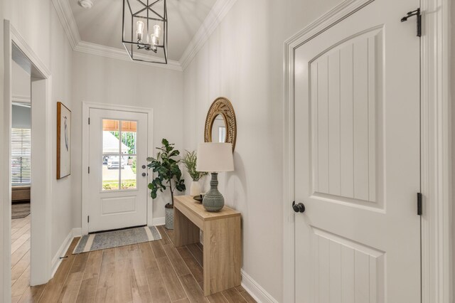 124 Apollo Ave, Freeport, FL 32439 - foyer entrance featuring ornamental molding, wood finished floors, and a chandelier