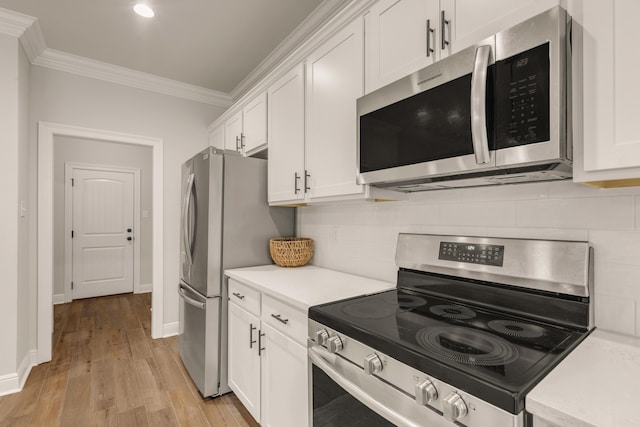 124 Apollo Ave, Freeport, FL 32439 - kitchen with appliances with stainless steel finishes, ornamental molding, light countertops, white cabinets, and light wood-type flooring
