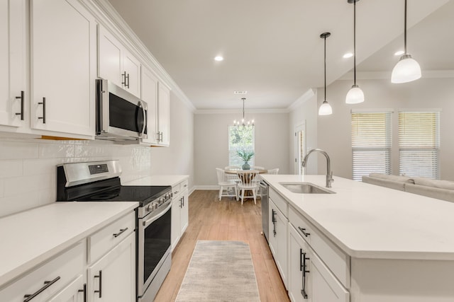 124 Apollo Ave, Freeport, FL 32439 - kitchen with appliances with stainless steel finishes, ornamental molding, light wood-type flooring, tasteful backsplash, and white cabinetry