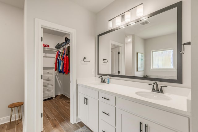 124 Apollo Ave, Freeport, FL 32439 - bathroom with double vanity, wood finished floors, and a spacious closet
