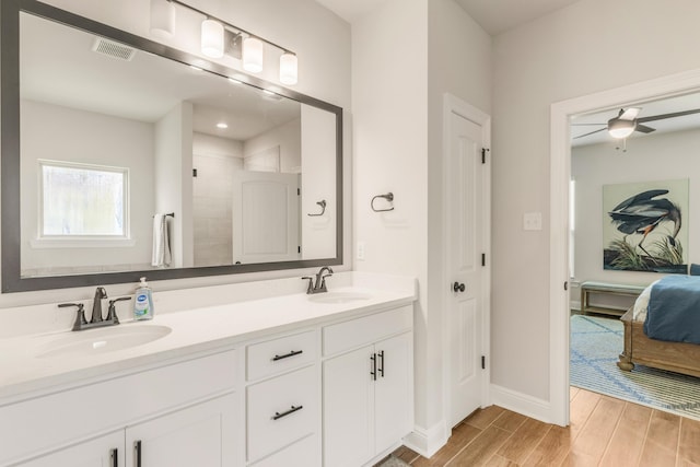 124 Apollo Ave, Freeport, FL 32439 - full bathroom with double vanity, wood finished floors, a ceiling fan, and ensuite bath
