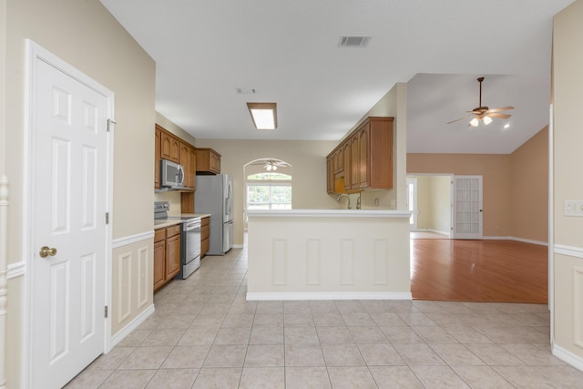 5552 Frontier Dr, Crestview, FL 32536 - kitchen featuring appliances with stainless steel finishes, a ceiling fan, brown cabinetry, light countertops, and open floor plan