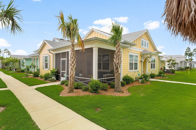 8668 Shell Sink Dr, Panama City Beach, FL 32413 - view of front of home featuring board and batten siding, a sunroom, and a front yard