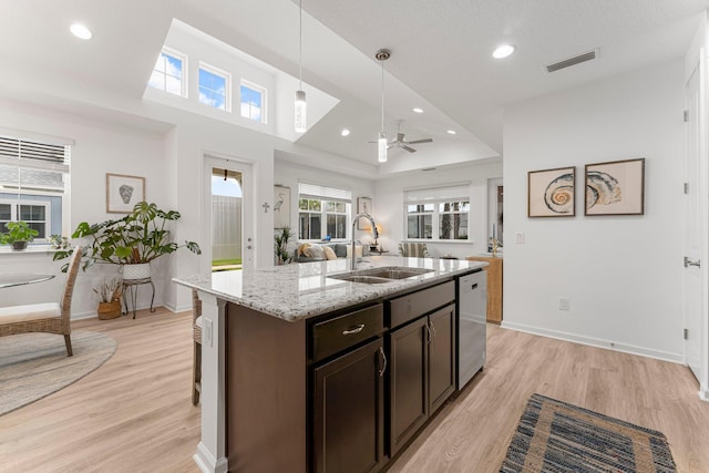 8668 Shell Sink Dr, Panama City Beach, FL 32413 - kitchen with stainless steel dishwasher, a ceiling fan, decorative light fixtures, light stone countertops, and dark brown cabinetry