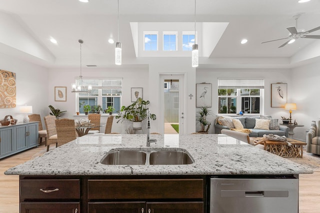 8668 Shell Sink Dr, Panama City Beach, FL 32413 - kitchen featuring lofted ceiling, open floor plan, stainless steel dishwasher, light wood-style floors, and dark brown cabinetry