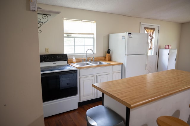 3180 Palmetta Ave, Crestview, FL 32539 - kitchen with range with electric stovetop, freestanding refrigerator, white cabinetry, dark wood-style flooring, and a textured ceiling