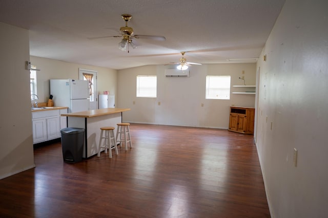 3180 Palmetta Ave, Crestview, FL 32539 - kitchen featuring a ceiling fan, a wall mounted air conditioner, freestanding refrigerator, and white cabinets