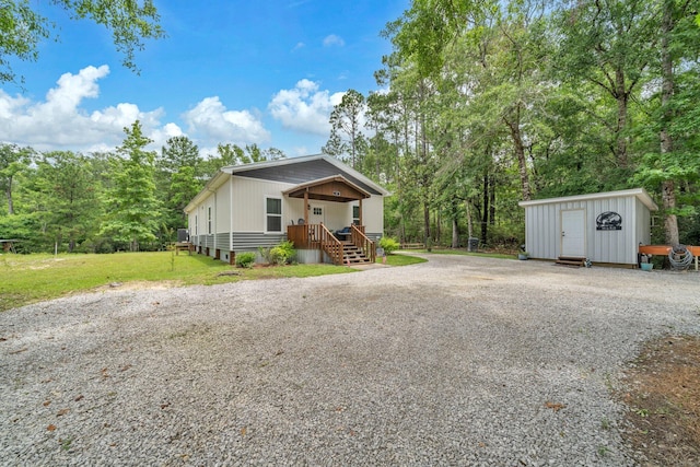 52 Lazy Bone St, Vernon, FL 32462 - manufactured / mobile home featuring gravel driveway, a shed, a front lawn, and board and batten siding