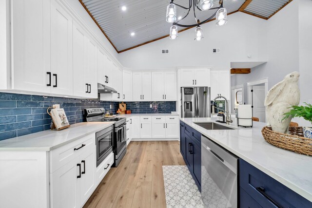 52 Lazy Bone St, Vernon, FL 32462 - kitchen featuring appliances with stainless steel finishes, blue cabinetry, light wood-style floors, white cabinetry, and high vaulted ceiling