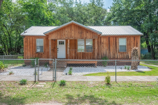 201 Anderson St, Crestview, FL 32536 - chalet / cabin featuring a gate, a fenced front yard, board and batten siding, and a metal roof