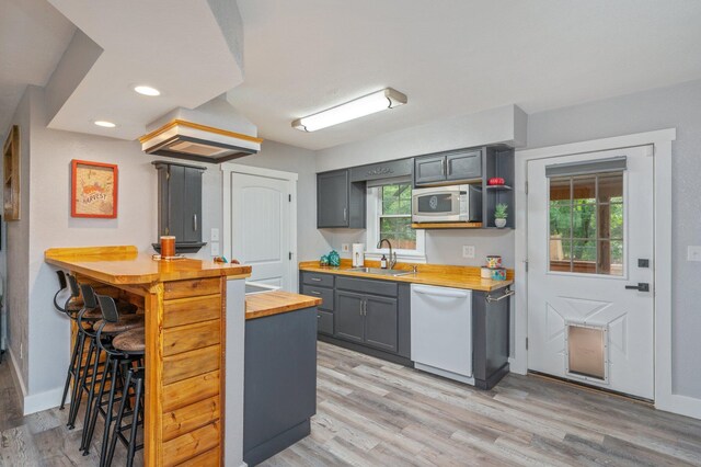 201 Anderson St, Crestview, FL 32536 - kitchen with butcher block countertops, stainless steel microwave, white dishwasher, light wood finished floors, and gray cabinetry