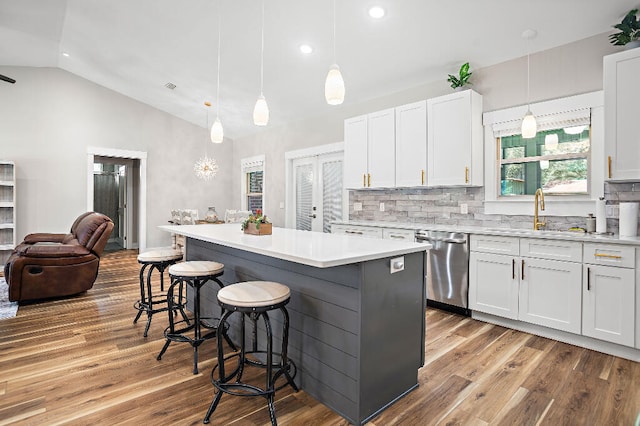3112 Evans Ave, Navarre, FL 32566 - kitchen featuring dishwasher, lofted ceiling, wood finished floors, open floor plan, and a breakfast bar area