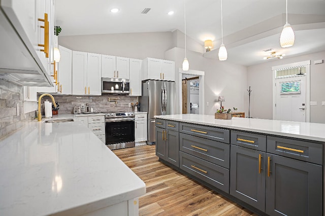 3112 Evans Ave, Navarre, FL 32566 - kitchen featuring stainless steel appliances, white cabinets, vaulted ceiling, backsplash, and light wood-style floors