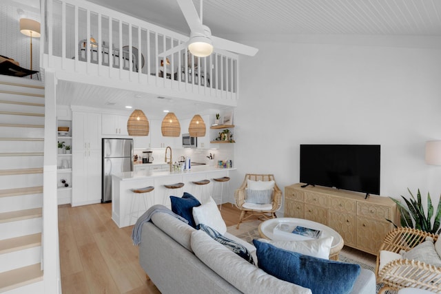 4984 W County Highway 30a Unit 5B, Santa Rosa Beach, FL 32459 - living area featuring stairway, light wood-style flooring, a ceiling fan, and a towering ceiling