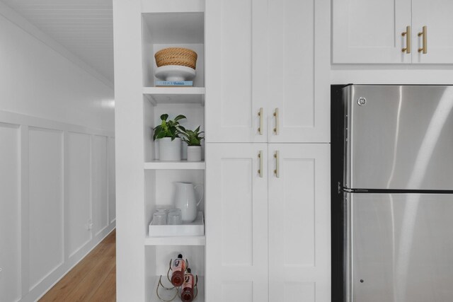 4984 W County Highway 30a Unit 5B, Santa Rosa Beach, FL 32459 - kitchen view of freestanding refrigerator, open shelves, wood finished floors, and white cabinets