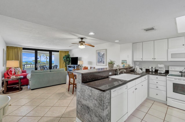 291 Scenic Gulf Dr Unit 400, Miramar Beach, FL 32550 - kitchen featuring white appliances, light tile patterned flooring, a peninsula, white cabinets, and open floor plan