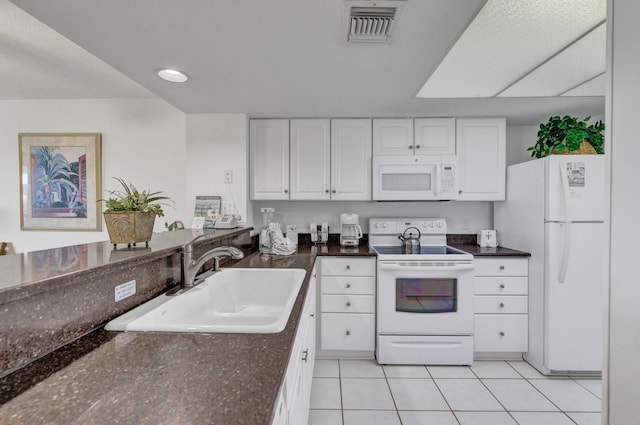 291 Scenic Gulf Dr Unit 400, Miramar Beach, FL 32550 - kitchen featuring white appliances, white cabinetry, light tile patterned floors, dark stone countertops, and recessed lighting