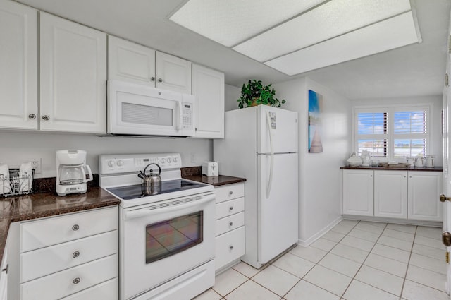 291 Scenic Gulf Dr Unit 400, Miramar Beach, FL 32550 - kitchen with white appliances, dark countertops, white cabinetry, and light tile patterned floors
