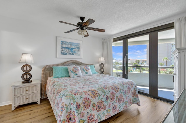 291 Scenic Gulf Dr Unit 400, Miramar Beach, FL 32550 - bedroom with access to outside, light wood-style flooring, a textured ceiling, and ceiling fan