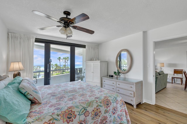 291 Scenic Gulf Dr Unit 400, Miramar Beach, FL 32550 - bedroom featuring access to outside, a textured ceiling, light wood-type flooring, and a ceiling fan