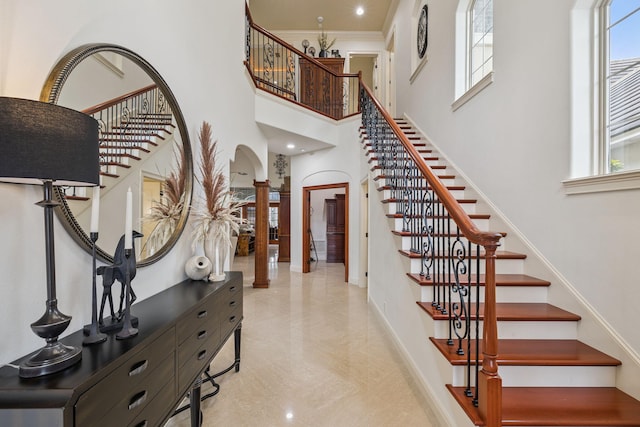 69 Cobalt Ln, Miramar Beach, FL 32550 - staircase with decorative columns, healthy amount of natural light, a high ceiling, and arched walkways