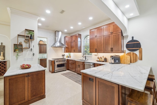 69 Cobalt Ln, Miramar Beach, FL 32550 - kitchen featuring stainless steel appliances, wall chimney range hood, crown molding, a peninsula, and light stone countertops