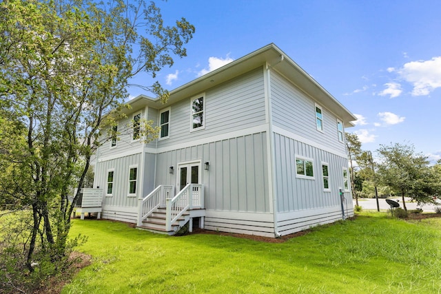 70 Oakley Ct, Santa Rosa Beach, FL 32459 - back of house featuring board and batten siding, a lawn, and french doors