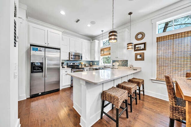 23 The Greenway Loop, Inlet Beach, FL 32461 - kitchen with stainless steel appliances, a kitchen bar, a peninsula, white cabinetry, and recessed lighting