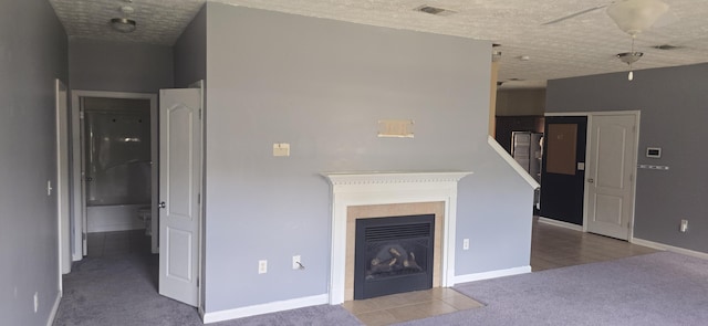2496 S Lakeview Dr, Crestview, FL 32536 - unfurnished living room featuring tile patterned flooring, a fireplace with flush hearth, carpet floors, and a textured ceiling
