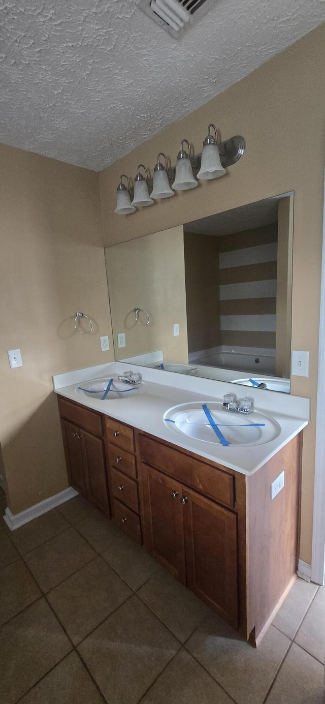 2496 S Lakeview Dr, Crestview, FL 32536 - full bathroom featuring tile patterned floors, double vanity, and a textured ceiling