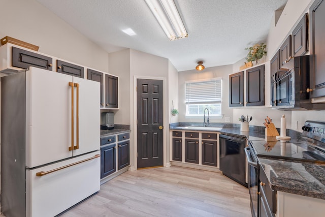 405 Bobby Dr, Crestview, FL 32536 - kitchen with black appliances, a textured ceiling, light wood-style flooring, and dark stone counters
