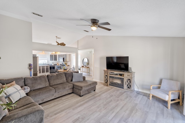 405 Bobby Dr, Crestview, FL 32536 - living room with lofted ceiling, a ceiling fan, light wood-style floors, and a textured ceiling