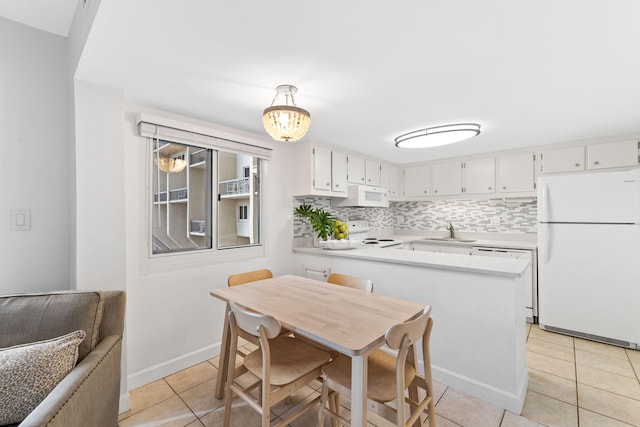 23223 Front Beach Rd # 112, Panama City Beach, FL 32413 - kitchen featuring white appliances, light tile patterned floors, a peninsula, and light countertops