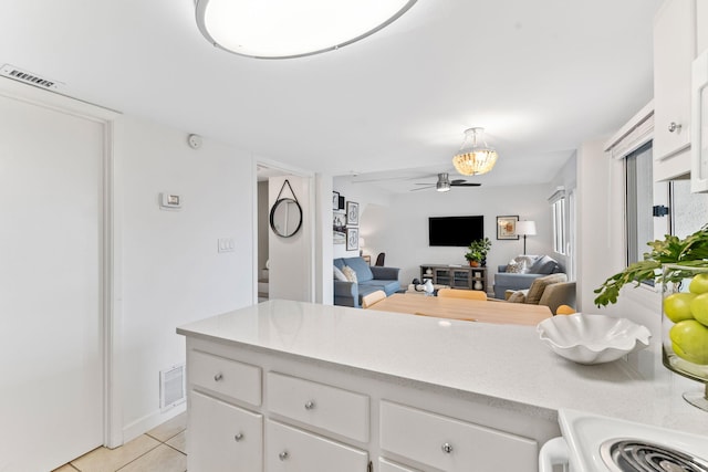 23223 Front Beach Rd # 112, Panama City Beach, FL 32413 - kitchen with light tile patterned floors, a ceiling fan, light countertops, and white cabinets