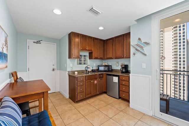 16701 Front Beach Rd Unit 1807, Panama City Beach, FL 32413 - kitchen with stainless steel dishwasher, black microwave, light tile patterned flooring, stone countertops, and brown cabinets