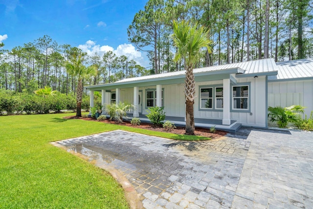 2672 Chat Holley Rd, Santa Rosa Beach, FL 32459 - view of front of house featuring board and batten siding, a porch, a front lawn, and a metal roof