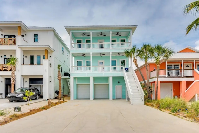 7411 Grand Navarre Blvd, Navarre, FL 32566 - coastal inspired home featuring a ceiling fan, stairway, a garage, and concrete driveway