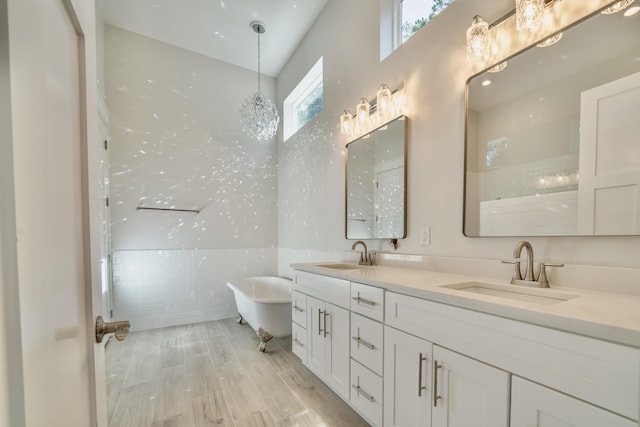 116 E Georgie Pt, Washington, FL 32459 - full bathroom with double vanity, a soaking tub, tile walls, and wood finished floors