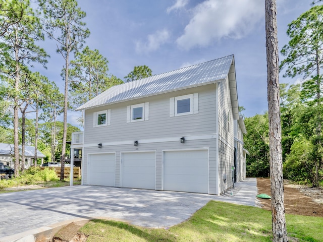 116 E Georgie Pt, Washington, FL 32459 - view of side of home featuring a garage, a metal roof, and concrete driveway