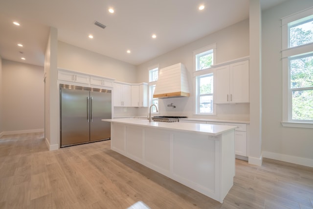 116 E Georgie Pt, Washington, FL 32459 - kitchen featuring built in fridge, custom range hood, light countertops, light wood-style flooring, and white cabinets