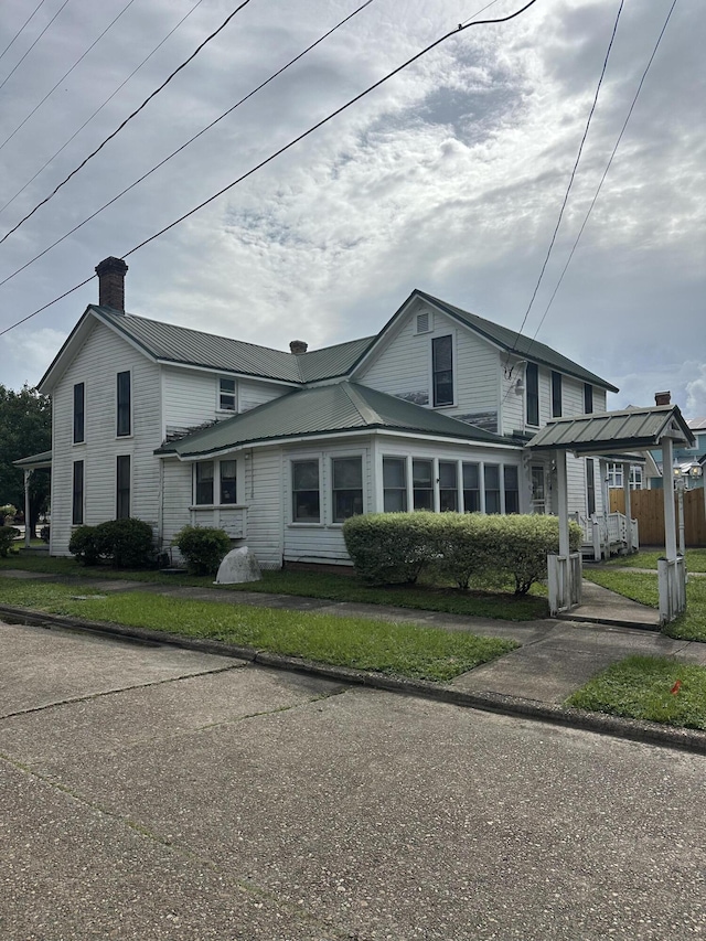 273 E Live Oak Ave, Defuniak Springs, FL 32435 - traditional-style home with a chimney and a metal roof