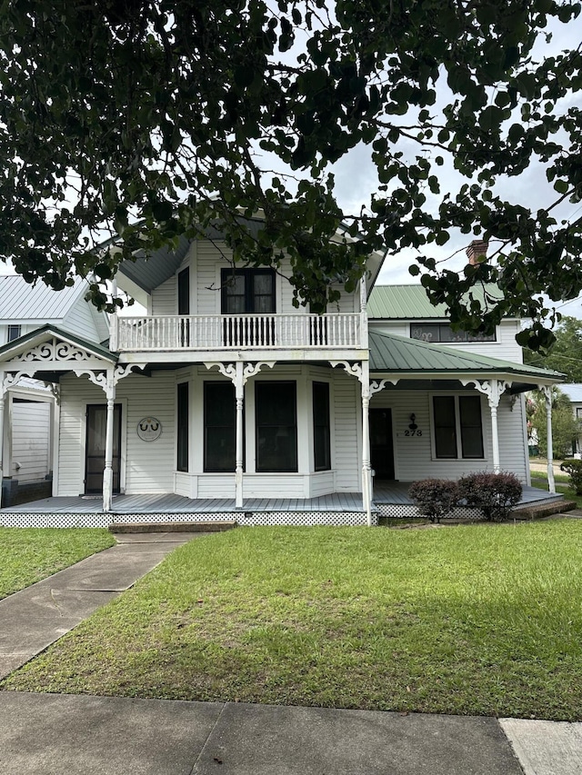 273 E Live Oak Ave, Defuniak Springs, FL 32435 - view of front facade featuring a porch, a balcony, and a front yard