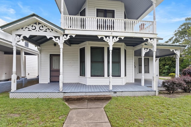 273 E Live Oak Ave, Defuniak Springs, FL 32435 - view of front of house featuring a balcony, a front yard, and a porch