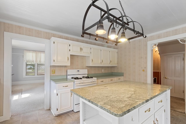 273 E Live Oak Ave, Defuniak Springs, FL 32435 - kitchen with white range with gas stovetop, wallpapered walls, white cabinets, crown molding, and light stone countertops