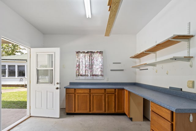 273 E Live Oak Ave, Defuniak Springs, FL 32435 - kitchen featuring open shelves, concrete flooring, brown cabinets, dark countertops, and beamed ceiling