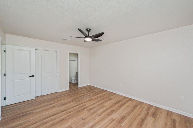 3375 Mclain Dr, Crestview, FL 32539 - unfurnished bedroom featuring light wood-style flooring, a closet, a ceiling fan, a textured ceiling, and ensuite bathroom