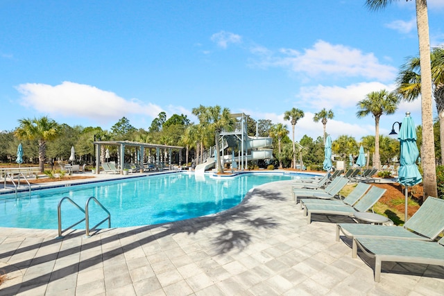 58 Pine Needle Way, Santa Rosa Beach, FL 32459 - community pool with a water slide, a patio area, view of scattered trees, and a pergola